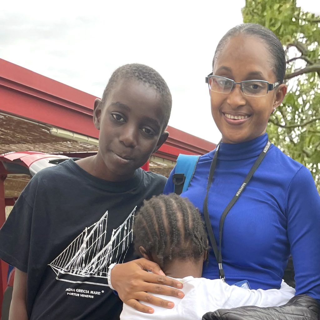 The children of La Maison share a moment of tenderness with Maimouna as she leaves for Guinea.